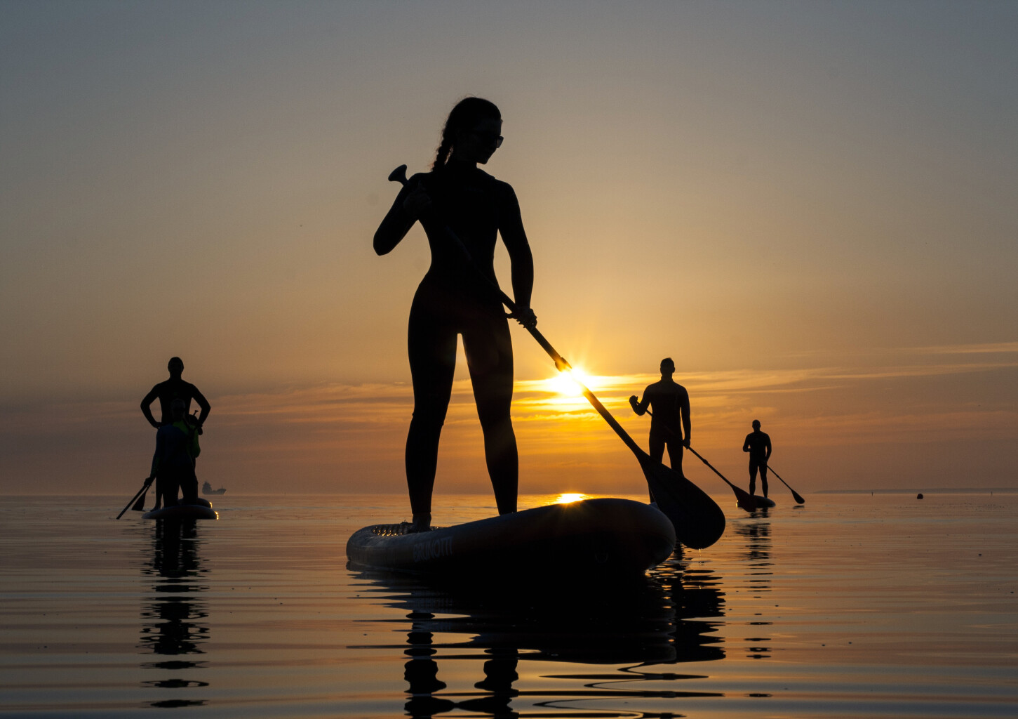 Морской поход SUP-серфингистов на закате 