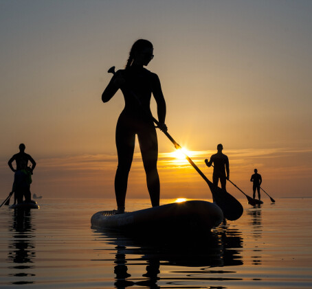 Морской поход SUP-серфингистов на закате 